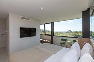 ein Schlafzimmer mit einem weißen Bett und einem großen Fenster in der Unterkunft Duinhotel Tien Torens in Zoutelande
