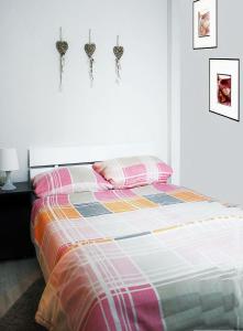 a bed with a colorful comforter and some ear hooks at Appartement Ernst in Celle