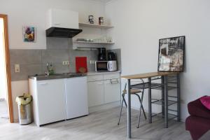 a small kitchen with a white refrigerator and a stool at Appartement Ernst in Celle