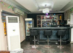 a bar with black bar stools in a room at Platinum Inn Gee Hotel in Suru Lere