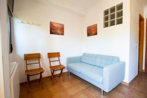 a living room with a blue couch and two chairs at Apartamentos Turisticos Trajano in Bolonia