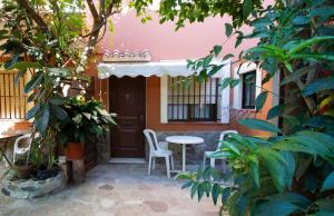 a patio with a table and chairs in front of a house at Apartamentos Turisticos Trajano in Bolonia