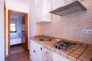 a kitchen with a sink and a stove top oven at Apartamentos Turisticos Trajano in Bolonia
