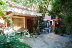 a patio of a house with chairs and trees at Apartamentos Turisticos Trajano in Bolonia