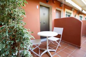 a white table and two chairs on a patio at Apartamentos Turisticos Trajano in Bolonia