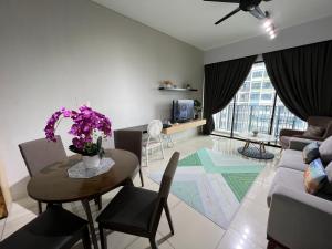 uma sala de estar com uma mesa e um sofá em D'Gunduls Homestay Family Suite 2R 2B by DGH I-CITY em Shah Alam