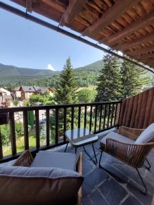 a balcony with chairs and a table and a view at Hotel Saurat in Espot