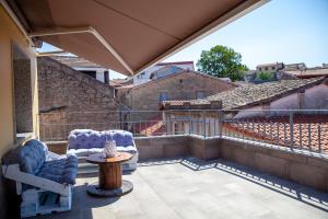 een patio met 2 stoelen en een tafel op een balkon bij A casa do Xastre in Allariz