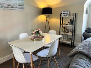 uma sala de jantar com uma mesa branca e cadeiras brancas em Stylish -2 Bed -Heart of the City - Parking- Wi-fi- Award Winning- Grade II Listed em Norwich