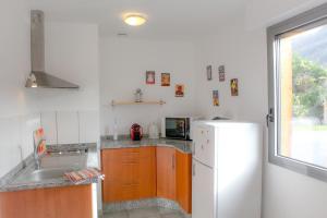 a kitchen with a white refrigerator and a sink at Le Domaine d'Arignac in Arignac