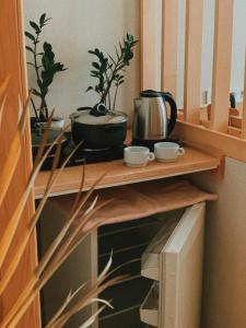 ein Holzregal mit einem Wasserkocher und Tassen darauf in der Unterkunft Ptcholkin's apartments in Lwiw