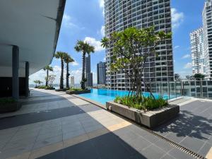 una piscina en la azotea de un edificio con palmeras en D'Gunduls Homestay Family Suite 2R 2B by DGH I-CITY, en Shah Alam