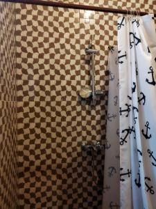 y baño con ducha y pared a cuadros. en Bethel House 2 Villas, en Abomey-Calavi