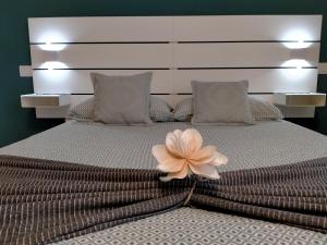uma cama grande com uma grande flor rosa em Le Case di Sonia TRE GEMME GIADA Fucecchio em Fucecchio