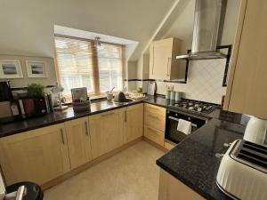 uma cozinha com armários de madeira e um forno com placa de fogão em Stylish -2 Bed -Heart of the City - Parking- Wi-fi- Award Winning- Grade II Listed em Norwich