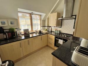 a kitchen with wooden cabinets and a stove top oven at Stylish -2 Bed -Heart of the City - Parking- Wi-fi- Award Winning- Grade II Listed in Norwich +22 photos
