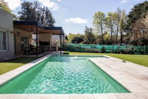 una piscina en el patio trasero de una casa en Divina casa con parque pileta en mini barrio cerrado. en Del Viso