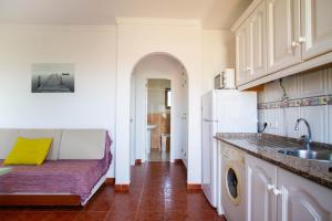 a kitchen with a couch and a sink at Apartamentos Turisticos Trajano in Bolonia