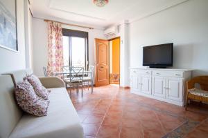 a living room with a couch and a flat screen tv at Apartamentos Turisticos Trajano in Bolonia