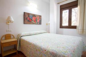a bedroom with a bed and a window at Apartamentos Turisticos Trajano in Bolonia