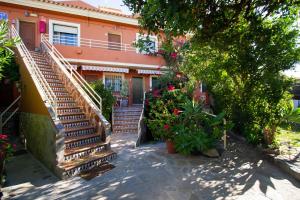 a building with stairs and flowers in front of it at Apartamentos Turisticos Trajano in Bolonia
