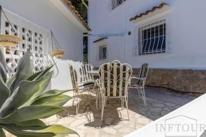 un patio con sedie, tavolo e piante di Inftour La Fustera Villa a Calpe