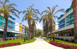 une passerelle avec des palmiers devant un bâtiment dans l'établissement Crystal Paraiso Verde Resort & Spa - Ultimate All Inclusive, à Belek