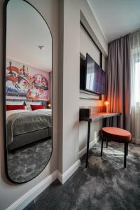 漢諾威的住宿－NYCE Hotel Hannover，一间带镜子、一张床和一张书桌的卧室
