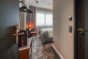 ein Hotelzimmer mit einem Bett und ein Zimmer mit einer Tür in der Unterkunft NYCE Hotel Hannover in Hannover
