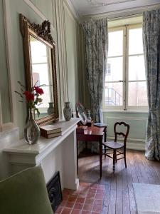 salon z lustrem, stołem i krzesłem w obiekcie Maison Zola w mieście Saint-Amand-Montrond