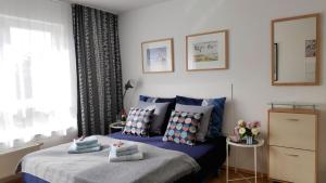 una camera da letto con letto blu, cuscini e finestra di Strandnahe Ferienwohnungen mit Garten a Ostseebad Koserow