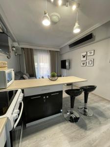 a kitchen with a counter and two stools in it at Seagull center kavala in Kavála