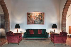 sala de estar con sofá verde y 2 sillas en The Club House en Castelnuovo Berardenga