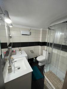 a bathroom with a sink and a shower and a toilet at Seagull center kavala in Kavála