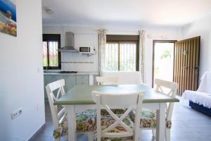 una cucina e una sala da pranzo con tavolo e sedie di Apartamentos Turisticos Trajano a Bolonia