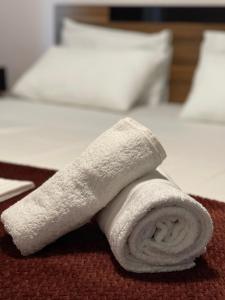 a white towel laying on top of a bed at Seagull center kavala in Kavála