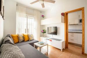 a living room with a couch and a tv at Apartamento centro Rota. 2 minutos de la playa.. in Rota