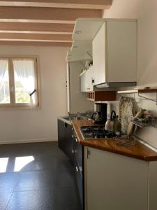 une cuisine avec des armoires blanches et un four à plaques de cuisson dans l'établissement Villa Arzilla, à Desenzano del Garda 23 autres photos