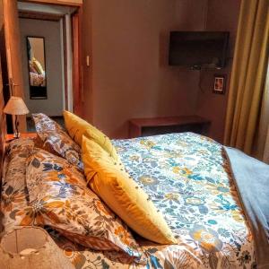 a bed with a comforter and pillows on it at Las Terrazas II in Villa Pehuenia