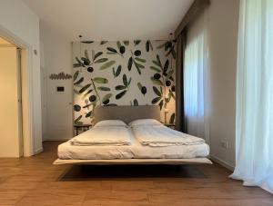 a bedroom with a bed with a floral wall at Agritur Fiore d'Ulivo in Riva del Garda