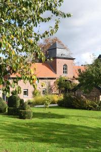 een groot bakstenen huis met een grasveld bij Vakantiewoningen - Buitenverblijf Huiskenshof Zuid-Limburg in Klimmen