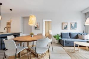 een woonkamer met een tafel en een blauwe bank bij INITIAL / ARTWOOD / Centre-ville de Quebec in Québec