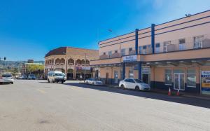 a city street with cars parked in front of buildings at Bayside Hotel Pietermaritzburg in Pietermaritzburg