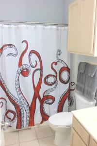 a bathroom with a shower curtain with red tentacles at Spacious Home, Short Walk to Beach, Heated Pool! in Corpus Christi