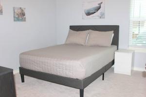 1 cama en un dormitorio con una pared blanca en Spacious Home, Short Walk to Beach, Heated Pool!, en Corpus Christi