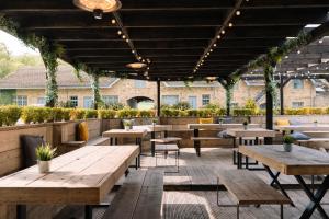 an outdoor patio with wooden tables and benches at Derwent Manor Boutique Hotel in Consett