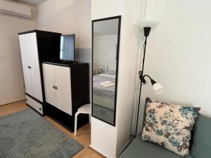 a bedroom with a mirror and a bed and a lamp at RETRO Apartments in Bjelovar