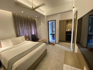 Priyo Nibash Stylish Residential Hotel في داكا: غرفة نوم بسرير كبير وغرفة معيشة