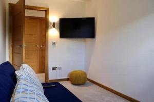 Habitación con cama y TV en la pared. en The Cottage - spacious getaway with stunning views, en Auchenblae