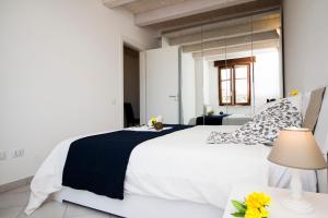 - une chambre blanche avec un grand lit et une table dans l'établissement InnPisaRentals - Charme Pisa Toscana 1, à Pise